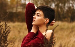 Brunette woman with an angled pixie cut with a side parting 